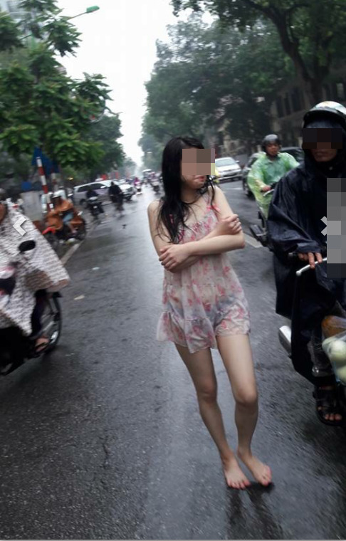 Hành động quá khó hiểu của cô gái giữa phố Hà Nội ngày mưa  - Ảnh 2.