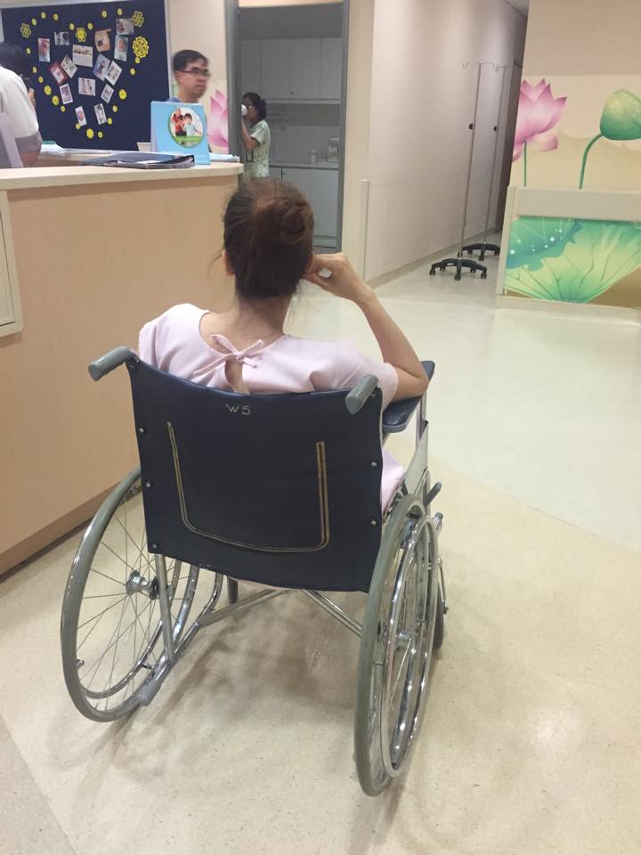 Kh&aacute;nh Thi ngồi xe lăn
