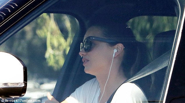 Miranda Kerr ngồi trên xe nghe nhạc