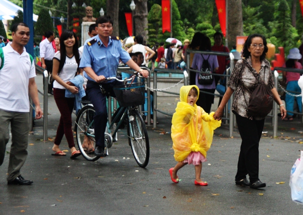 Sài Gòn mưa rả rích suốt lễ, các bé mặc áo mưa đi chơi 15