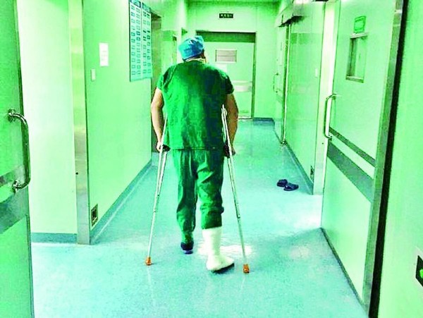 H&igrave;nh ảnh vị b&aacute;c sĩ chống nạng bước v&agrave;o ph&ograve;ng mổ g&acirc;y x&uacute;c động mạnh