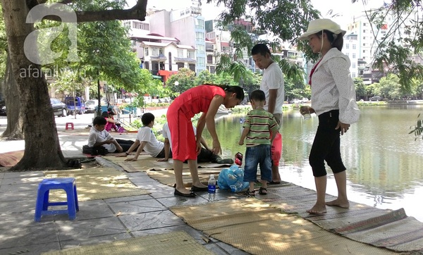 Chờ khám bệnh, mang con ra hồ Ngọc Khánh thuê 20 nghìn tiền chiếu nằm nghỉ 14