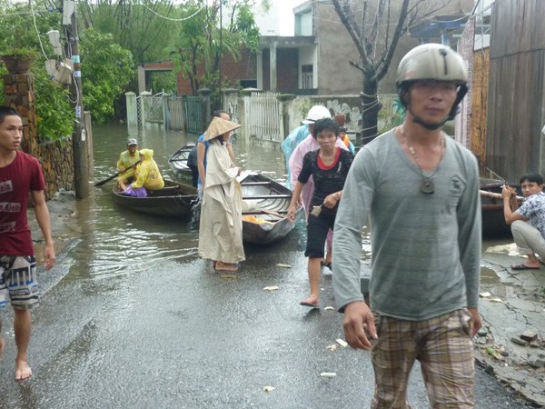 Nước lũ lênh láng, người dân mặc áo mưa, lội nước đi... xem 11