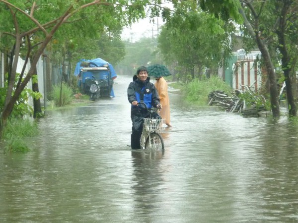 Nước lũ lênh láng, người dân mặc áo mưa, lội nước đi... xem 10