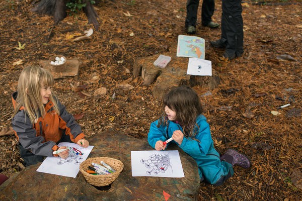 Stelyn Carter, 5 tuổi và Alma Essers, 3 tuổi dùng gốc cây làm bàn học.