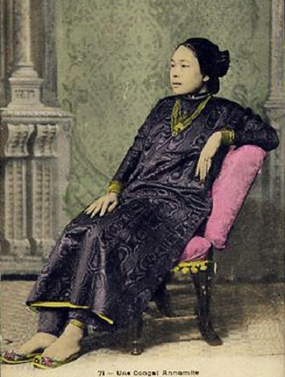 Một phụ nữ nhà giàu trong tà áo dài hoa văn độc đáo và trang sức vàng.