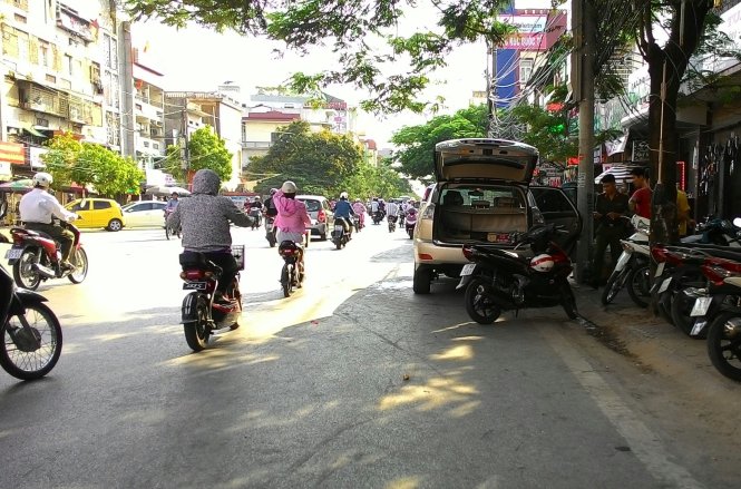 Cơ quan công an khám nghiệm hiện trường chiếc xe ô tô mà đôi nam nữ bị tạt axit trong chiều 21-6 - Ảnh: Tiến Thắng