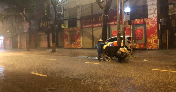 Chạnh lòng với hình ảnh cô lao công dọn rác bên lề đường trong đêm 30 Tết mưa bão