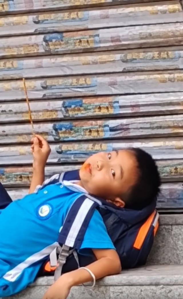 Mẹ đến đón muộn, cậu bé thản nhiên nằm trên bậc thềm ăn đồ ăn: Dân mạng bật cười vì quá chill! - Ảnh 3.
