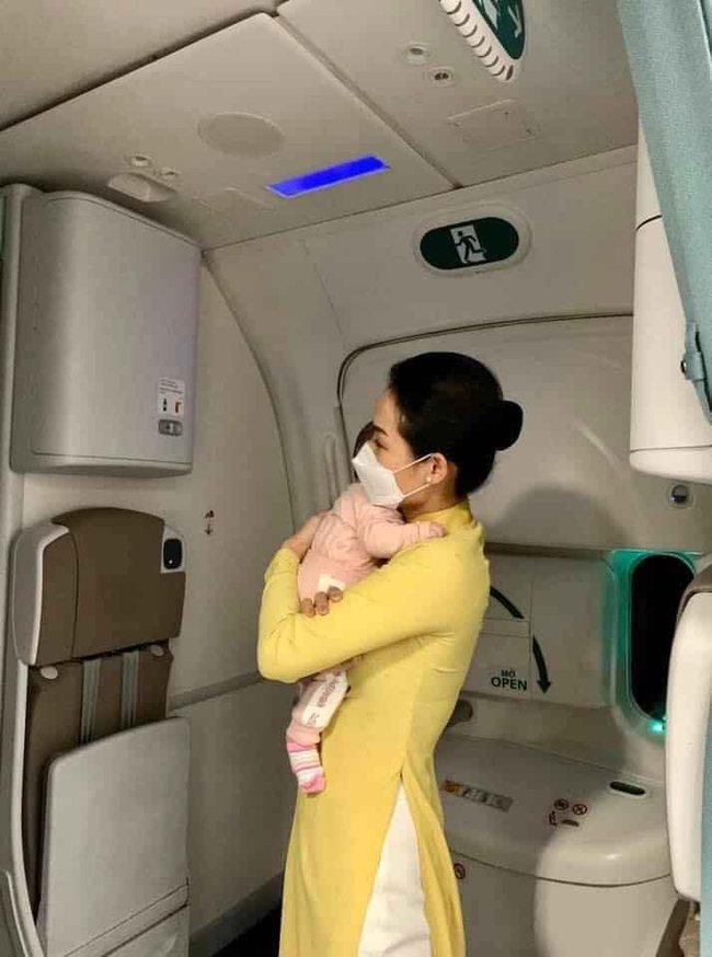 Hình ảnh nữ tiếp viên hàng không tận tình bế ẵm em bé mới 2 tháng tuổi đã phải xa mẹ về Việt Nam được Thân Thúy Hà, Hồng Quế chia sẻ đầy xúc động - Ảnh 1.