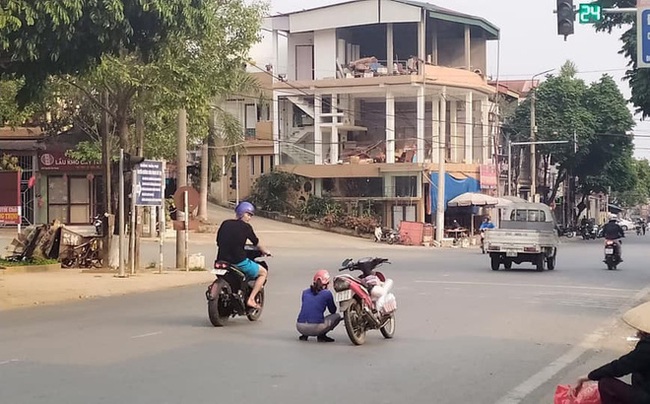 Đang đi xe máy, người phụ nữ bỗng nhảy xuống xe rồi ngồi giữa đường, hành động lạ kì này khiến ai nấy đều thắc mắc - Ảnh 2.