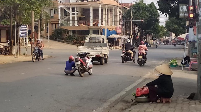 Đang đi xe máy, người phụ nữ bỗng nhảy xuống xe rồi ngồi giữa đường, hành động lạ kì này khiến ai nấy đều thắc mắc - Ảnh 1.