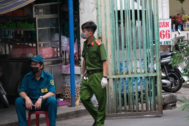 An ninh tại chung cư có ca nhiễm Covid-19 thắt chặt: Hàng rào đóng kín, cơm nước được tiếp tế thẳng vào trong - Ảnh 4.