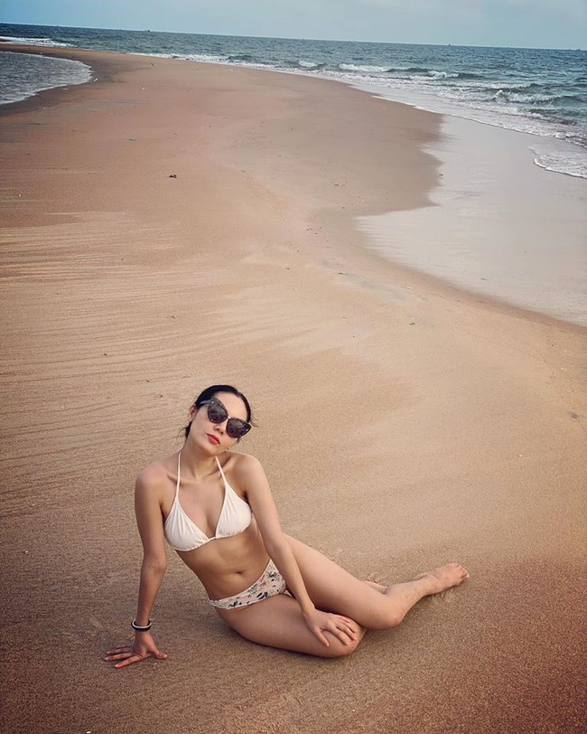 Phương Linh diện bikini gợi cảm, ngồi tạo dáng trên bãi cát.
