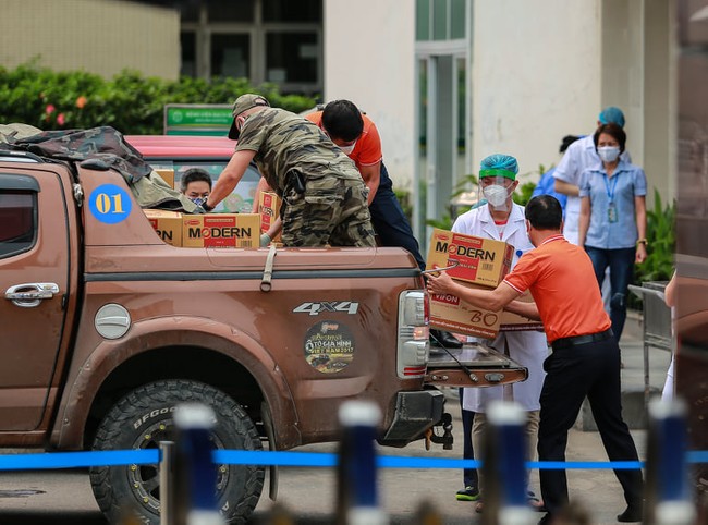 Chùm ảnh: Đội ngũ nhân viên y tế cùng lực lượng chức năng trực chiến trước cổng bệnh viện Bạch Mai, người dân tiếp tế nhu yếu phẩm được yêu cầu mang về  - Ảnh 10.