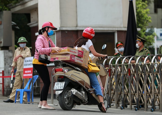 Chùm ảnh: Đội ngũ nhân viên y tế cùng lực lượng chức năng trực chiến trước cổng bệnh viện Bạch Mai, người dân tiếp tế nhu yếu phẩm được yêu cầu mang về  - Ảnh 16.