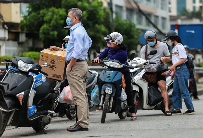 Chùm ảnh: Đội ngũ nhân viên y tế cùng lực lượng chức năng trực chiến trước cổng bệnh viện Bạch Mai, người dân tiếp tế nhu yếu phẩm được yêu cầu mang về  - Ảnh 12.