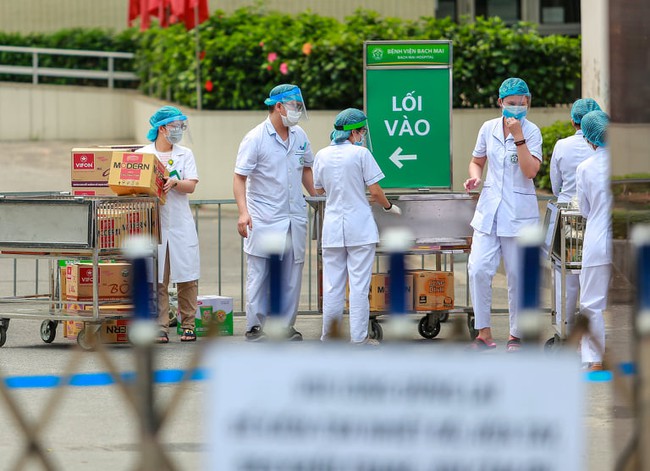 Chùm ảnh: Đội ngũ nhân viên y tế cùng lực lượng chức năng trực chiến trước cổng bệnh viện Bạch Mai, người dân tiếp tế nhu yếu phẩm được yêu cầu mang về  - Ảnh 11.