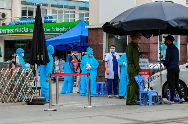Chùm ảnh: Đội ngũ nhân viên y tế cùng lực lượng chức năng trực chiến trước cổng bệnh viện Bạch Mai, người dân tiếp tế nhu yếu phẩm được yêu cầu mang về  - Ảnh 3.