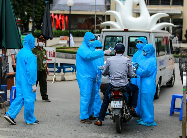 Chùm ảnh: Đội ngũ nhân viên y tế cùng lực lượng chức năng trực chiến trước cổng bệnh viện Bạch Mai, người dân tiếp tế nhu yếu phẩm được yêu cầu mang về  - Ảnh 5.