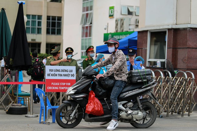 Chùm ảnh: Đội ngũ nhân viên y tế cùng lực lượng chức năng trực chiến trước cổng bệnh viện Bạch Mai, người dân tiếp tế nhu yếu phẩm được yêu cầu mang về  - Ảnh 15.