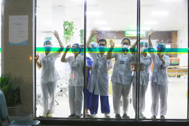 Hình ảnh các y bác sĩ tại Bệnh viện Bạch Mai vẫy tay chào qua cửa kính: Họ vẫn ngày đêm chiến đấu ở tuyến đầu nhưng vẫn luôn lạc quan như vậy - Ảnh 1.