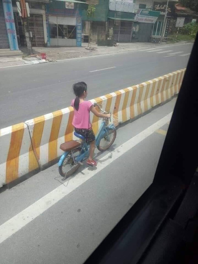 Bé gái đi xe đạp bị kẹt ở dải phân cách không thể sang đường, tài xế xe khách đã có hành động đặc biệt khiến dân mạng cảm kích - Ảnh 1.