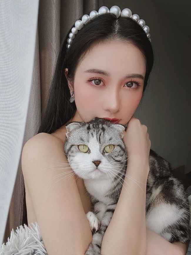 Jun Vũ âu yếm mèo cưng trước ống kính máy ảnh.