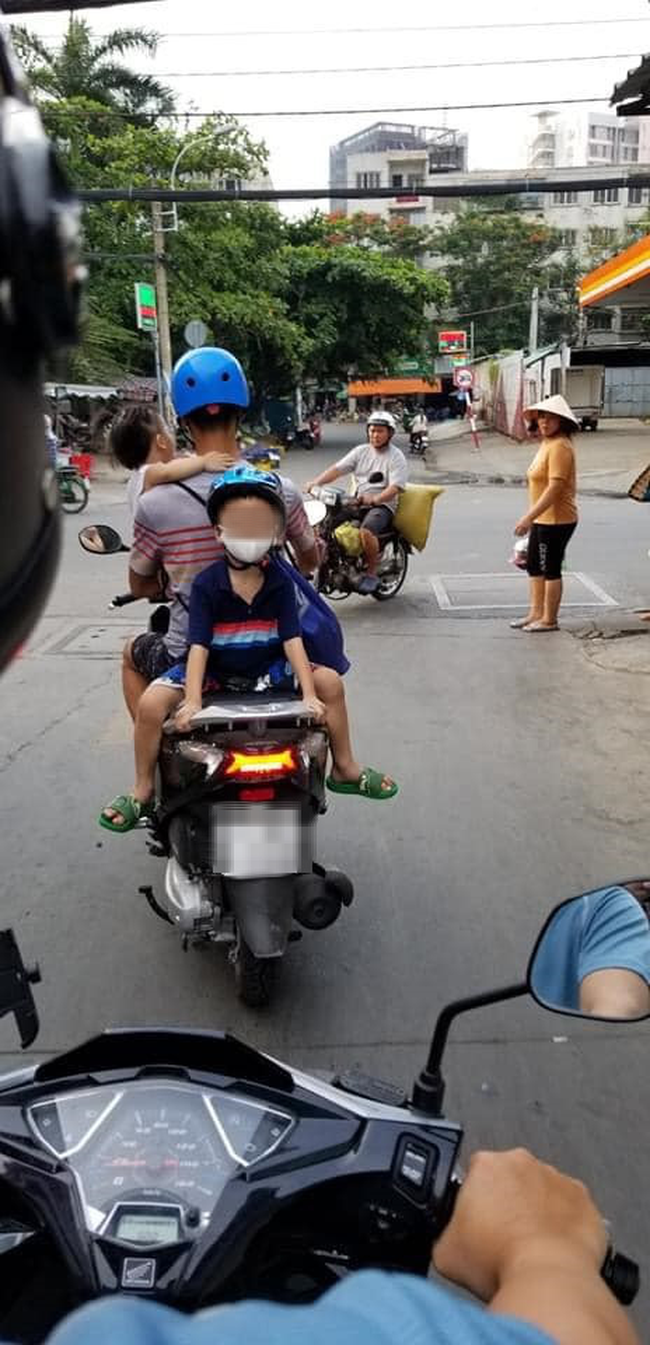 Bố chở con đi chơi bằng xe máy, nhưng vị trí ngồi của 2 đứa nhỏ ...