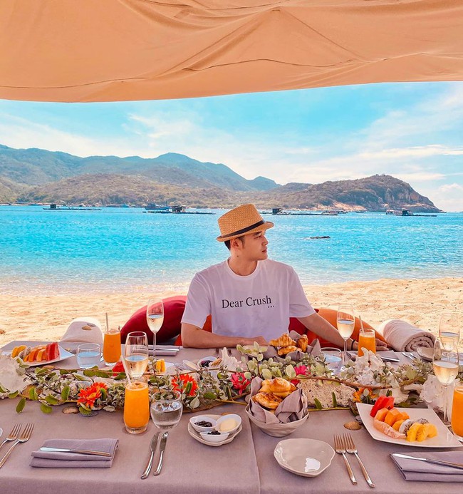 Quang Vinh up hình ngồi thưởng thức đồ ăn ngon giữa biển trời thơ mộng.