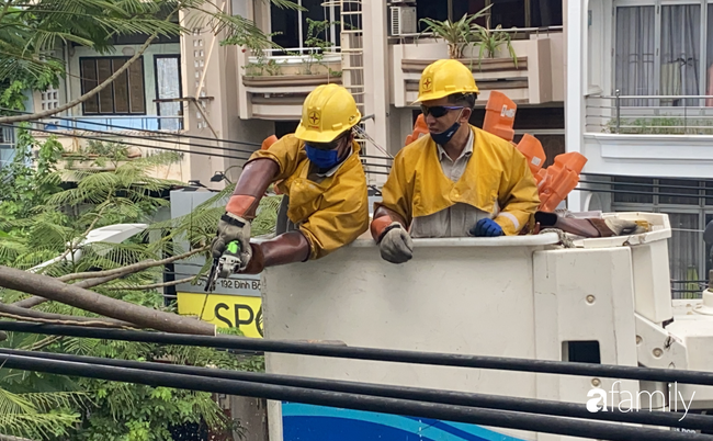 TP.HCM: Công nhân &quot;treo mình&quot; trên xe thang cao cắt cành phượng lớn bị gãy gần đường điện nguy hiểm, giữ an toàn mùa mưa bão - Ảnh 7.