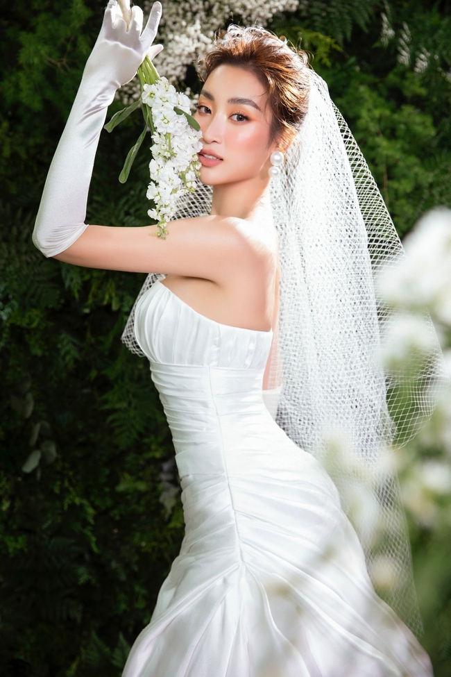 Hoa hậu Đỗ Mỹ Linh hóa cô dâu lạc giữa rừng hoa, khoe vẻ đẹp hút hồn cùng thân hình đồng hồ cát quyến rũ - Ảnh 1.