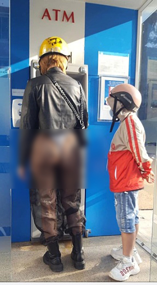 Người phụ nữ dẫn theo đứa trẻ đi rút tiền ở cây ATM gây bức xúc khi mặc chiếc quần &quot;xuyên thấu&quot; đầy phản cảm  - Ảnh 1.