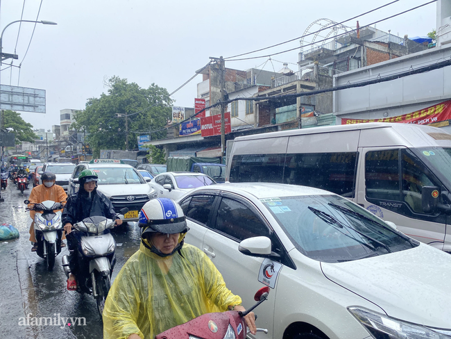 Mưa lớn liên tục nhiều giờ gây ngập sâu, người dân TP.HCM ngao ngán tìm cách chắn cửa ngăn nước tràn vào nhà - Ảnh 2.