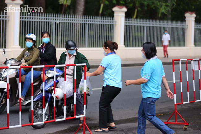 Ngày thứ hai kỳ thi tốt nghiệp THPT 2021: Phụ huynh đội mưa đưa con đến điểm thi, khu vực có thí sinh cách ly tăng cường hơn biện pháp phòng chống dịch - Ảnh 2.