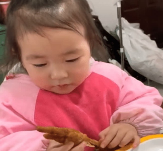 Đang gặm chân gà ngon lành, bé gái giật mình phát hiện "có gì đó không ổn", biểu cảm khó hiểu của cô bé gây sốt cộng đồng mạng - Ảnh 1. Đang gặm chân gà ngon lành, bé gái giật mình phát hiện "có gì đó không ổn", biểu cảm khó hiểu của cô bé gây sốt cộng đồng mạng - Ảnh 1.