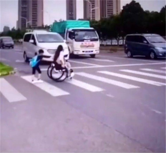 Cậu bé đẩy xe lăn đưa mẹ qua đường thì ai cũng phải khen Cậu bé đẩy xe lăn đưa mẹ qua đường thì ai cũng phải khen