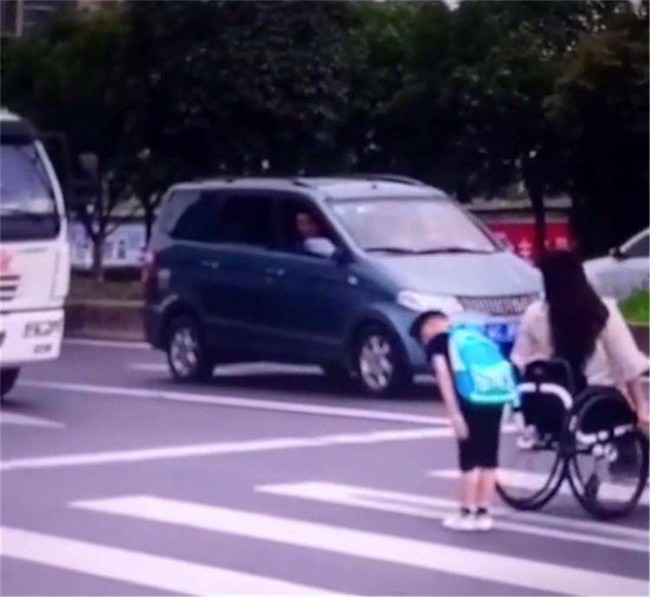 Cậu bé đẩy xe lăn đưa mẹ qua đường sau pha bóng khiến ai cũng phải khen ngợi 