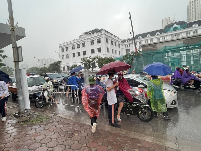 Thi tốt nghiệp THPT chiều 7/7: Trời Hà Nội đổ mưa to, sĩ tử cuống cuồng chạy vào trường thi - Ảnh 1.