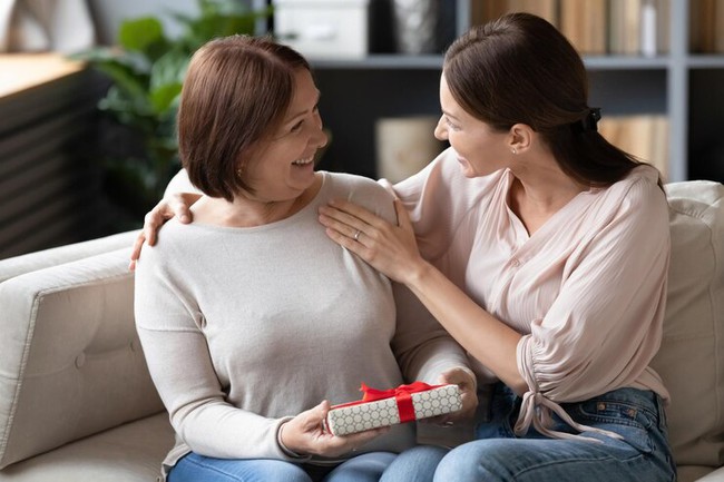 -smiling-older-mother-with-birthday-mothers-day-8-march-happy-excited-mature-woman-holding-gift-box-with-red-bow-sitting-couch-home650366-7004-17277677356151910550106.jpg