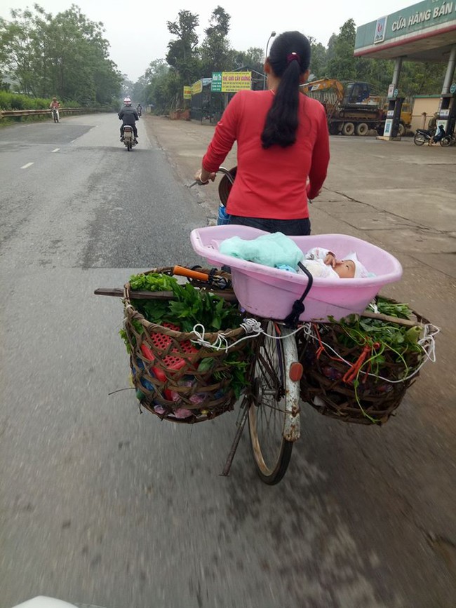 Xúc động hình ảnh mẹ bán rau, bỏ con trong thau đạp xe đi muôn nơi…. - Ảnh 1.