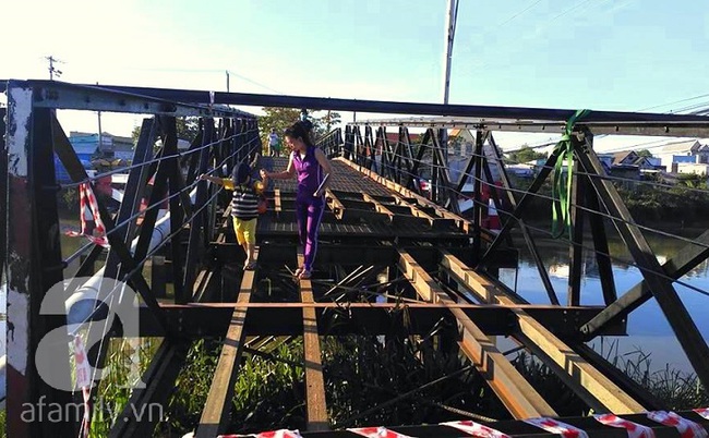 Rùng mình chứng kiến cảnh cha mẹ cõng con đánh liều đi qua cây cầu chênh vênh đang sửa chữa ở Sài Gòn - Ảnh 2.