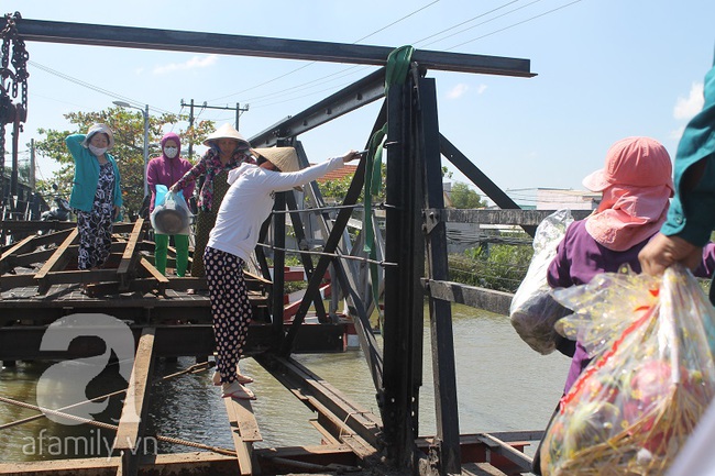 Rùng mình chứng kiến cảnh cha mẹ cõng con đánh liều đi qua cây cầu chênh vênh đang sửa chữa ở Sài Gòn - Ảnh 1.