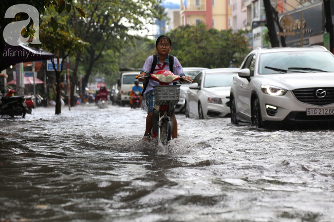Mưa chỉ 15 phút, đường Sài Gòn lại biến thành sông khiến học sinh bì bõm lội nước về nhà giờ tan trường - Ảnh 7.