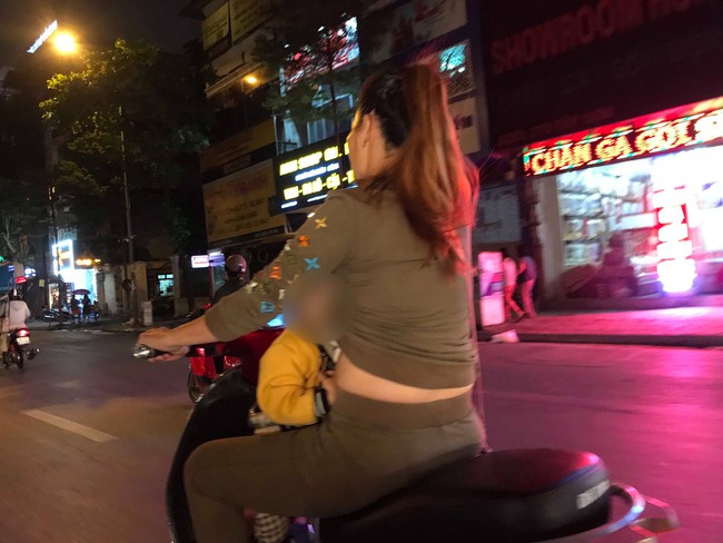 Người mẹ một tay cầm lái, một tay ôm con trai đang ti sữa trên đường phố Hà Nội khiến nhiều người ngỡ ngàng - Ảnh 1.