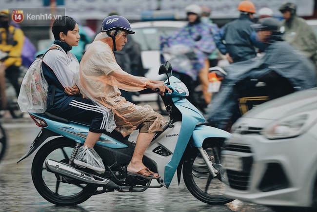 Chùm ảnh: Sau một đêm trở gió Hà Nội mưa lạnh xuống đến 17 độ C, người dân co ro ra đường - Ảnh 1.