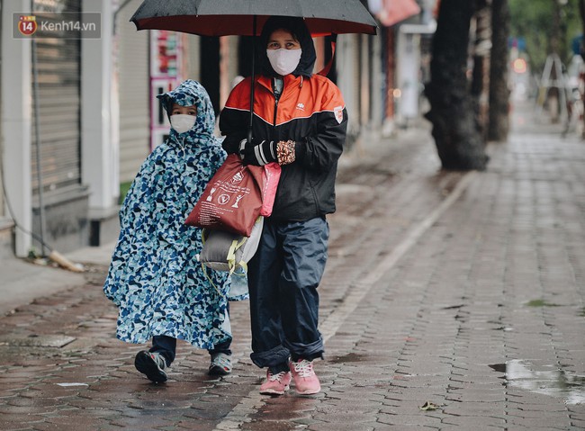 Chùm ảnh: Sau một đêm trở gió Hà Nội mưa lạnh xuống đến 17 độ C, người dân co ro ra đường - Ảnh 2.