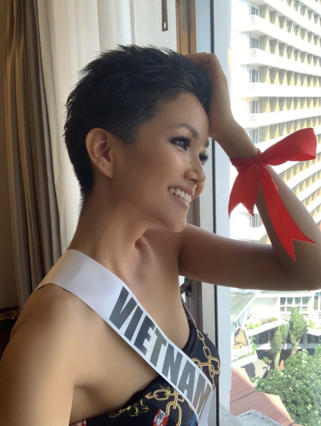 Bất ngờ trước ý nghĩa dải ruy băng đỏ luôn đồng hành trên tay Hoa hậu HHen Niê  - Ảnh 1.