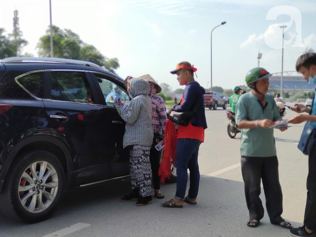 Không khí trước trận tuyển Việt Nam vs Malaysia: Phe vé xuống giá nài nỉ người mua, dân đứng nắng bán áo và cờ đỏ sao vàng - Ảnh 2.