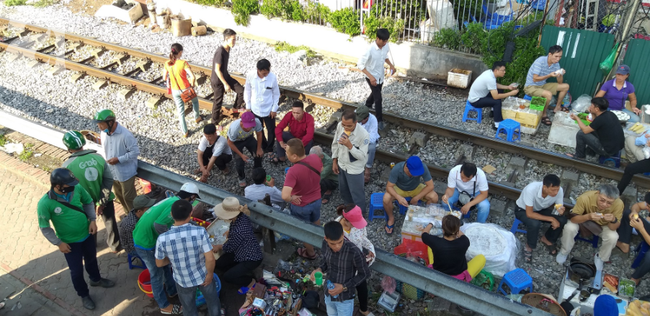 Hà Nội: Bệnh nhân bất chấp tính mạng ngồi ăn vặt, trà đá ngay trên đường tàu trước cổng bệnh viện  - Ảnh 2.